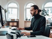 Comment faire le hashtag sur clavier azerty à partir de votre smartphone Bearded office worker with long hairs types on keyboard in office