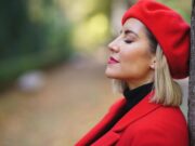 Comment la couleur influence l’impact de votre photo de profil stylé Close-up profile picture of a middle-aged woman leaning against a tree trunk with her eyes closed.