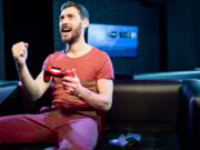 Avis sur le jeu LustGoddessGame.net : notre test Happy man playing video games with gaming console in the club