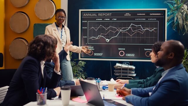 Marketing assistant presenting infographics in a status update meeting Marketing assistant presenting infographics in a status update meeting