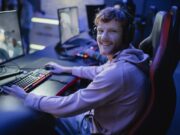 Gaming écoresponsable : vers un loisir numérique plus durable en 2025 ? Smiling gamer looking at camera while playing video game in cyber club
