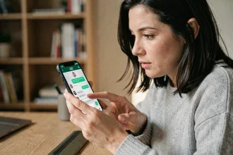 Femme utilisant WhatsApp sur iPhone pour surligner un message texte avec son pouce