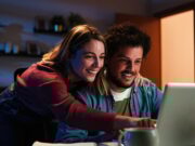 Comment les plateformes de location transforment la recherche de logement Young happy caucasian couple browsing on internet using a laptop to search sale at home. Excited