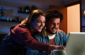 Comment les plateformes de location transforment la recherche de logement Young happy caucasian couple browsing on internet using a laptop to search sale at home. Excited